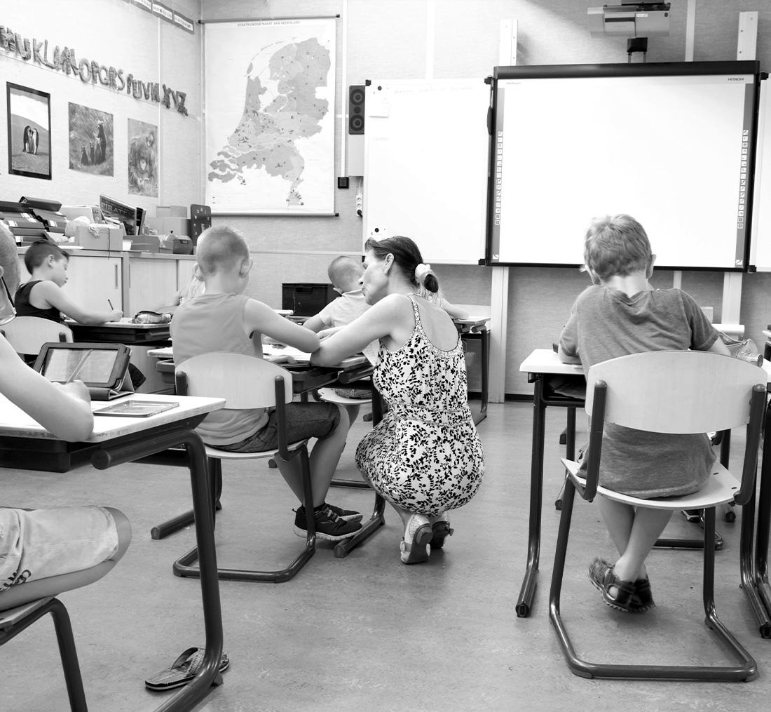 a teacher and children in a classroom with educational equipment