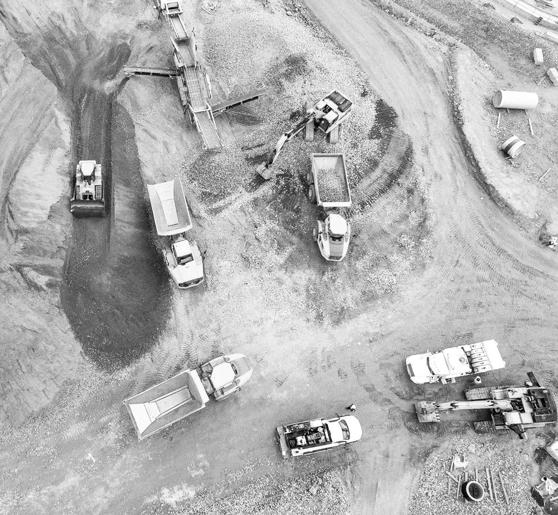 several mining trucks parked at a mine